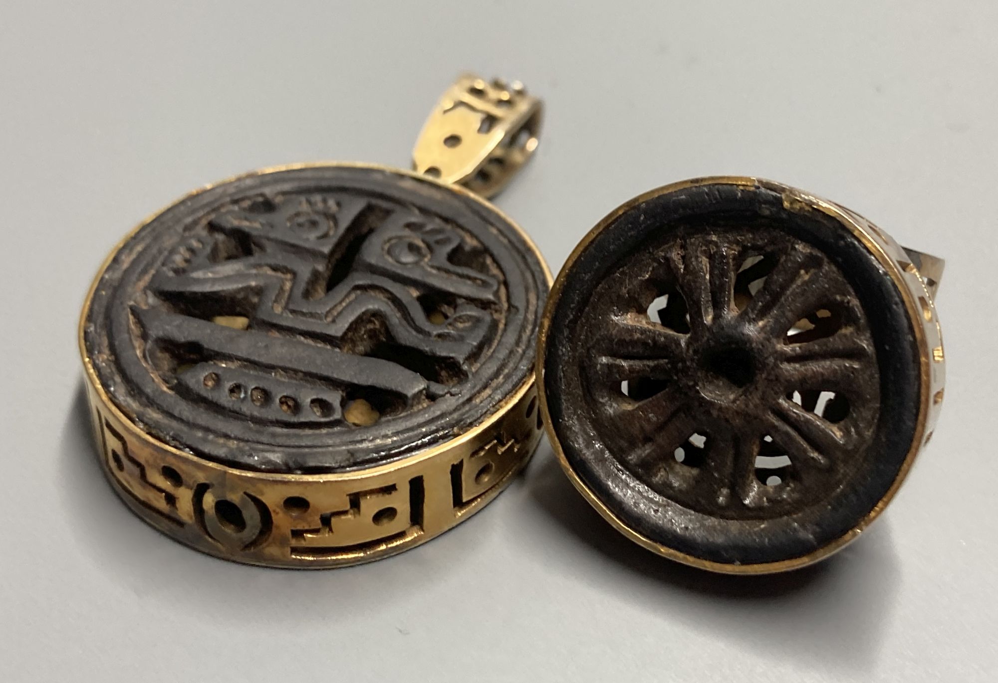 An unusual Chinese pierced gilt metal and base metal inset ring, size P, and matching pendant, overall 53mm.